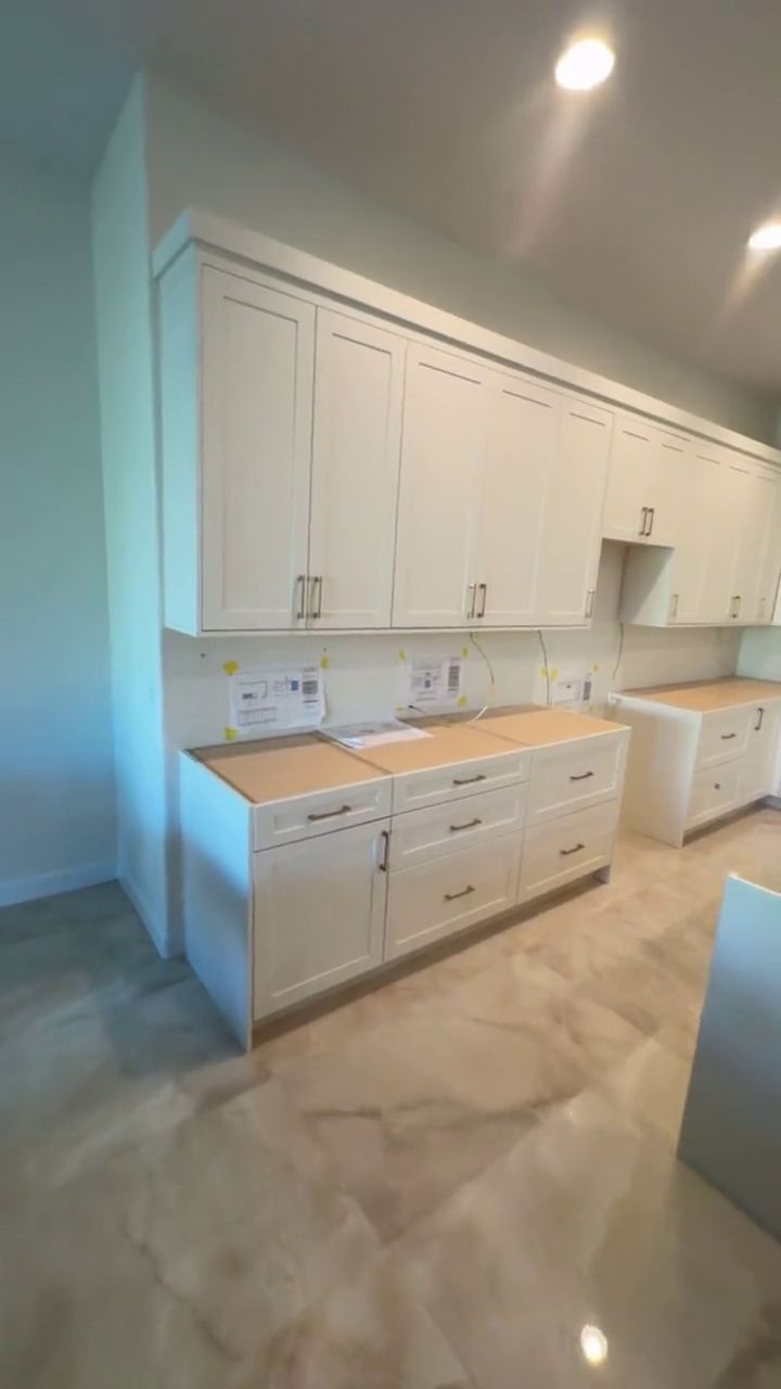 Cabinetry Install — Walking a fresh run of shaker uppers and base cabinets, set level and scribed to the wall.