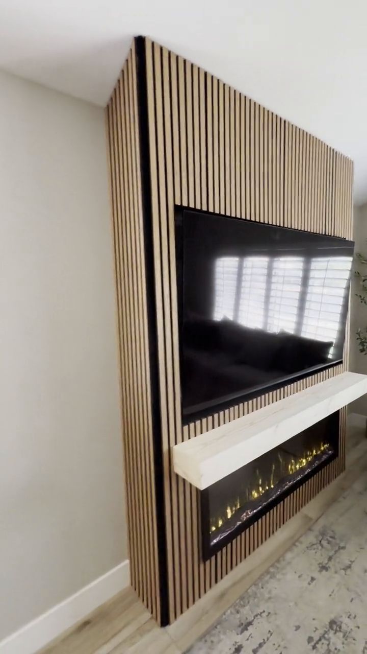 Slat Wall & Linear Fireplace — A full-height slat feature wall wrapping a recessed TV, floating mantel, and linear fireplace.